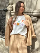 Remera blanca de algodón con cuello redondo y estampado de estrellas de mar de diferentes colores.