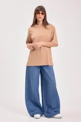 Remera color tostado de algodón con cuello redondo y mangas cortas. Estampado pequeño en el centro del pecho con un sol y texto.