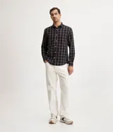Camisa de franela a cuadros color negro, con botones blancos y corte clásico.