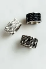 Anillo ancho de acero quirúrgico plateado, recubierto con cristales negros tipo pavé.