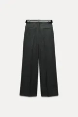 Pantalón negro de tiro alto con pinzas delanteras, pernera ancha y cinturón de cuero con hebilla dorada.