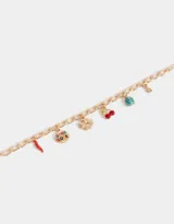 Pulsera dorada con eslabones gruesos y charms colgantes: pimiento rojo, moneda con la inscripción 'Good Luck', trébol de cuatro hojas, cerezas rojas y mariquita turquesa.