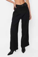 Pantalón sastrero negro, de calce tiro bajo y fit Relax. Con pinzas en delantero, detalle de cintura deshilachada y cartera de acceso curva. Presillas y bolsillos escondidos en los laterales.