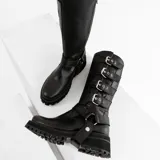 Bota alta de cuero vacuno color negro, con suela de goma artesanal, cierre interno YKK, hebillas ajustables y estribo desmontable.