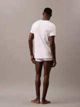 Pack de tres remeras Calvin Klein blancas de algodón, con cuello en V y logo bordado en el dobladillo.