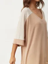 Remera color beige con escote en V y mangas cortas ranglán en color crema.