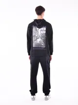 Buzo hoodie gris con bolsillo canguro y capucha con cordones ajustables. Diseño holgado con puños y cintura acanalados.