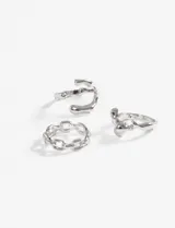 Set de tres anillos plateados de zinc, uno tipo ear cuff con forma ondulada, otro con eslabones y otro con forma orgánica.