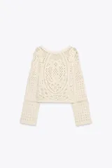 Top color crudo de tejido crochet calado, con cuello redondo y mangas largas acampanadas.