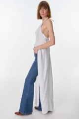 Conjunto de top halter con abertura en el abdomen y falda cruzada con ruedo desflecado, color fucsia.