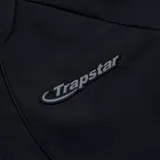 Campera negra con capucha y cierre frontal con el logo de Trapstar en el pecho.
