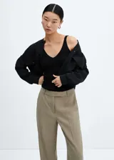 Top negro de punto fino con escote pico, tirantes finos y espalda abierta.