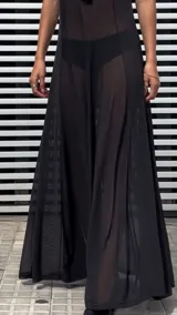 Vestido largo negro de microtul, corte evasé y breteles finos.
