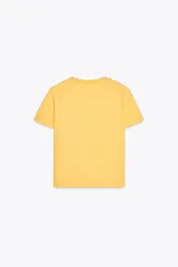 Camiseta amarilla de algodón con cuello redondo, manga corta y estampado marrón con el texto "New York Fluxus 1970".