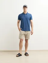 Chomba azul marino con pequeños lunares blancos, cuello clásico con botones y mangas cortas.