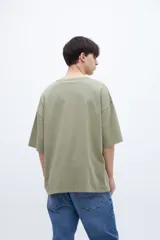 Remera color gris claro, de algodón lavado con textura extra suave, calce boxy y bolsillo en el pecho.