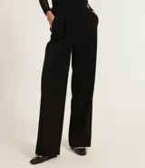 Pantalón de vestir negro de corte sastrero, confeccionado en poliéster, viscosa y elastano. Presenta cintura ancha con cintos laterales ajustables.