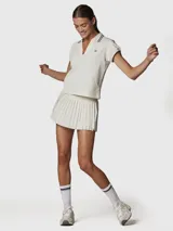 Polera manga corta color blanco tiza, con cuello polo y escote en V. Presenta dos rayas azules en el cuello y un logo bordado en negro en el pecho.