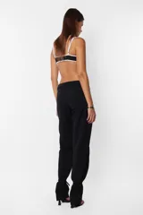 Pantalón de vestir gris, de corte recto y tiro medio. Presenta detalle de falsa cintura con presillas y cinto tira incluido.
