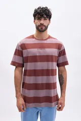 Remera de manga corta, cuello redondo y corte holgado, con rayas horizontales en tonos marrón rojizo y malva. Presenta un pequeño bordado con el texto "NO CONNECTION" en el pecho.