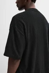 Sudadera negra de tejido texturizado con mezcla de algodón. Corte relaxed fit, cuello redondo y manga corta.