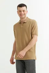 Chomba color beige de piqué de algodón, con cuello clásico y tapeta de dos botones. Manga corta con puños acanalados.