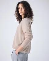 Sweater de cashmere color lila con cuello en V, corte oversize, mangas largas, hombros caídos y terminaciones acanaladas.