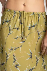 Falda midi color verde oliva con estampado de ramas y hojas en tonos grises y blancos. Tiene cintura elastizada con cordón ajustable y un tajo lateral.