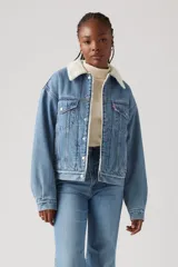 Campera de jean celeste con cuello de sherpa color crema, bolsillos frontales con solapa y cierre con botones metálicos.
