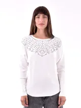 Sweater de punto color blanco, con cuello redondo y diseño con tachas plateadas en la parte superior.