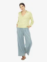 Pantalón celeste amplio de tencel con caída suave y pinzas delanteras. Tiene tiro alto y cintura elástica en la parte trasera.