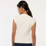 Top blanco sin mangas con cuello alto y botón decorativo en el hombro.