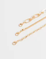 Set de tres collares dorados de metal con diferentes tipos de eslabones.