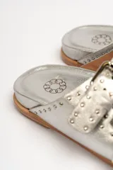 Sandalias marrones de cuero vacuno con doble tira y hebillas metálicas ajustables.