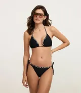 Bikini negro con corpiño triangular con detalle de trenza bicolor en los bordes y bombacha con lazos laterales y detalle de trenza bicolor en la cintura.
