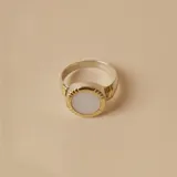 Anillo con base ancha de plata 925 y detalles en oro, con dije ovalado de nácar.