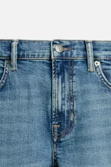 Pantalón de jean azul oscuro, corte slim fit, tiro medio, cinco bolsillos, tejido elástico y efecto lavado.