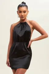 Vestido corto blanco de satén con escote halter con cadena dorada y espalda descubierta.