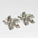 Par de caravanas plateadas con forma de flor de seis pétalos con textura. Cierre a presión.