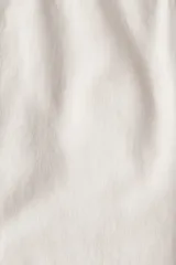 Pantalón color crema de corte ancho, con cintura elástica ajustable con cordón. Confeccionado en tejido de mezcla de lino y viscosa.