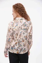 Camisa de seda con estampado de flores azules sobre fondo claro, de manga larga y corte clásico.