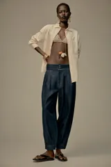 Camisa color crema de hilatura con algodón y lyocell, con cuello solapa, manga larga acabada en puño y bolsillo de plastrón en el delantero.