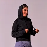 Hoodie deportivo negro con capucha y cordones ajustables, confeccionado en tejido de red con sutil estampado camuflado.