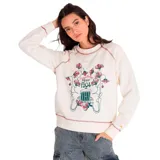 Buzo color crema de corte clásico, con cuello redondo y mangas largas raglán. Presenta un estampado central con flores y texto en tonos rosa y verde. Tiene costuras en contraste color rosa en cuello, puños y ruedo.
