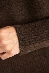 Sweater color marrón claro de tejido de punto, con cuello redondo y mangas largas.