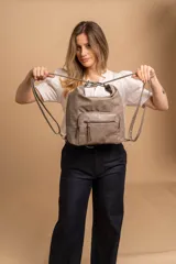 Cartera mochila color tostado, símil cuero, con compartimiento principal amplio y bolsillos frontales con cierre. Tiene correas ajustables para usar como mochila y asa superior para llevar al hombro.
