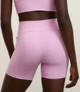 Bermuda deportiva de microfibra pesada color lila, sin estampa y con bolsillos laterales.