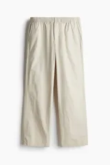 Pantalón color beige de popelina de algodón, corte ancho, con cintura elástica ajustable con cordón, bolsillos laterales y traseros.