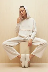 Canguro marrón con capucha, corte amplio y detalle de recorte frontal.