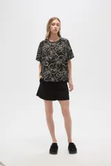 Blusa verde militar con estampado de flores blancas, de viscosa, corte holgado, cuello redondo y mangas cortas.